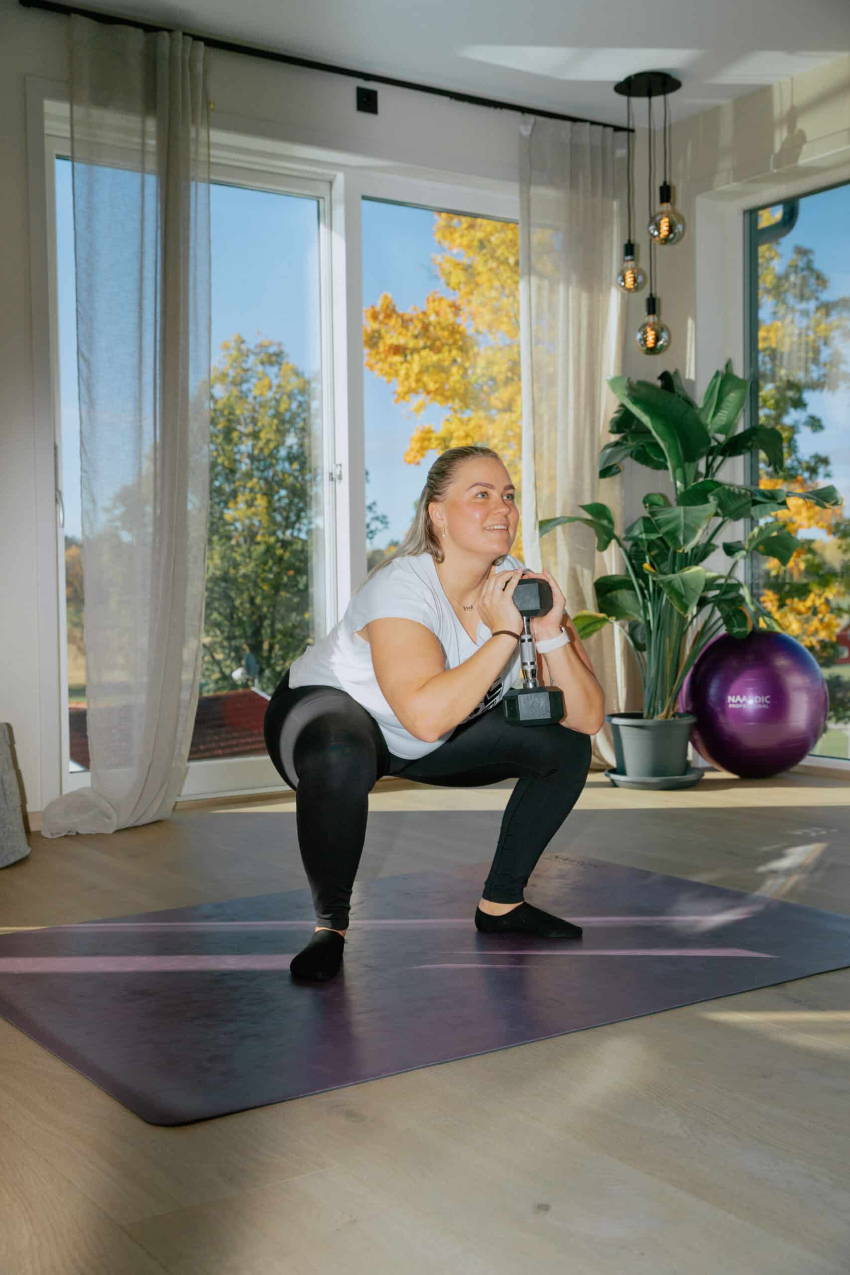 Naardic kunde gjør goblet squats hjemme i stua